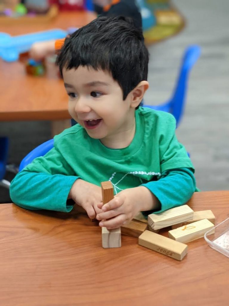 Happy Monarch Montessori Student Playing with Blocks